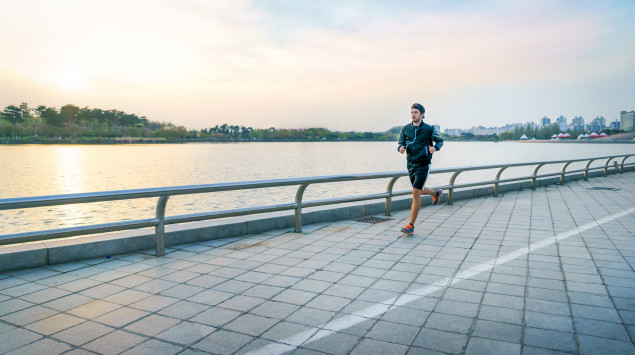 Ein Mann joggt einen Fluss entlang.