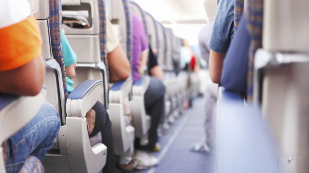 Man sieht den Gang eines vollbesetzten Flugzeugs