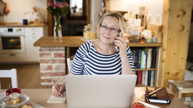 Eine Frau mittleren Alters am Telefon.