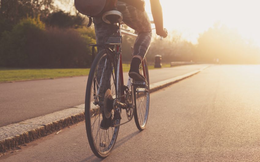 Vitamin D: Eine junge Frau fährt mit dem Rad auf einer Straße.