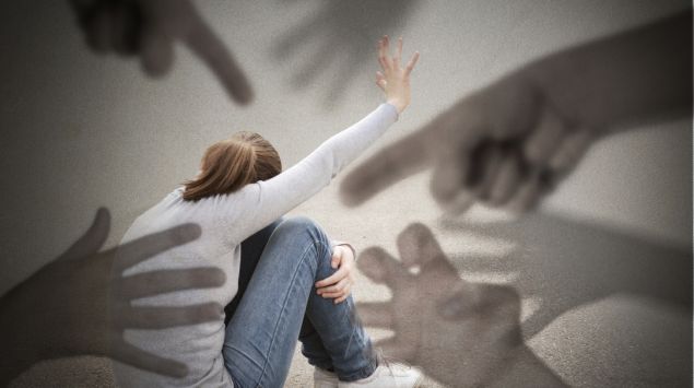 Eine Frau fühlt sich bedroht: Wahnvorstellungen zählen zu möglichen Symptomen einer Schizophrenie.