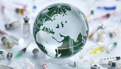Weltkugel mit Spritzen und Pillen