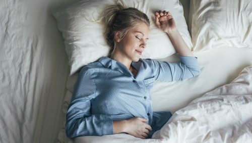 Eine Frau liegt im Bett und schläft.