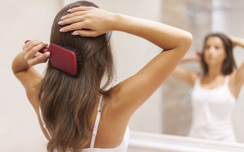 Eine Frau kämmt sich die Haare.
