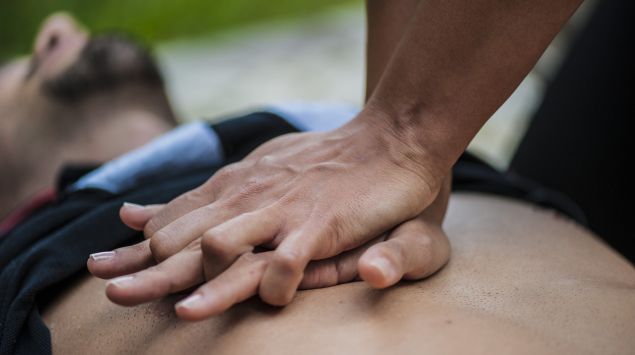 Jemand führt bei einem Mann eine Herzdruckmassage durch.