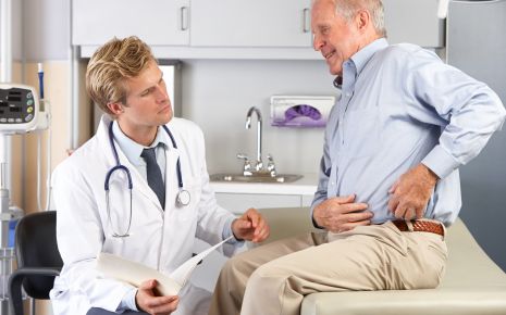 Ein Arzt im Gespräch mit einem älteren Patienten.