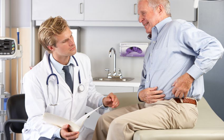 Ein Arzt im Gespräch mit einem älteren Patienten.