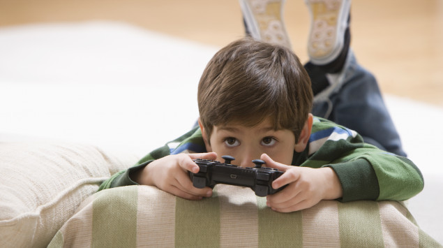 Ein Junge liegt auf dem Boden und spielt ein Videospiel