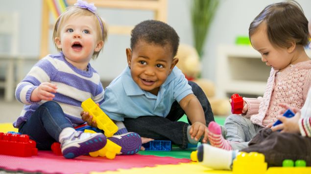 Drei kleine Kinder spielen.