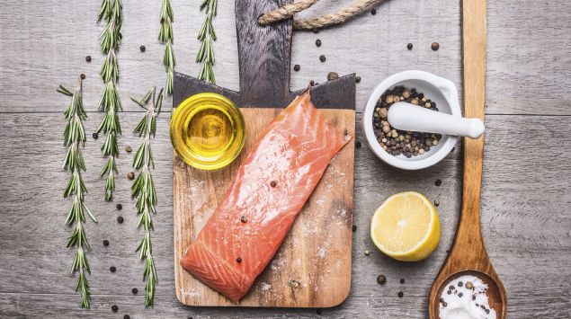 Das Bild zeigt ein Stück Lachs auf einem Holzbrett.