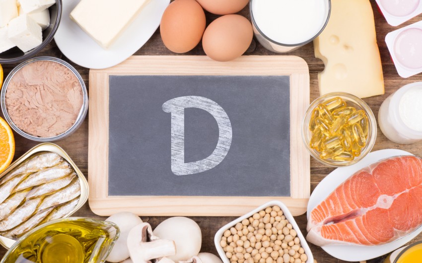 Vitamin D: Man sieht verschiedene Lebensmittel und eine Schiefertafel mit einem großen D.