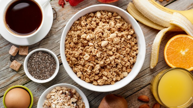 Eine Schüssel Müsli mit Kaffee, Banane und Saft