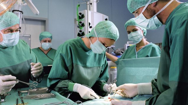 Das Bild zeigt mehrere Chirurgen bei einer Operation.