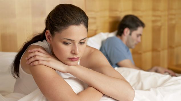 Ein Paar im Bett, beide Partner sehen frustriert aus.