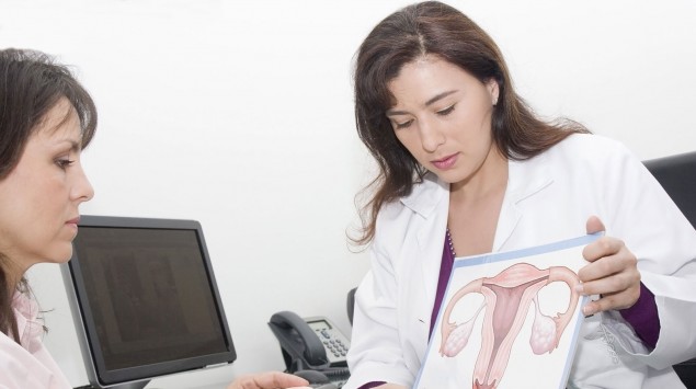 Eine Frauenärztin zeigt ihrer Patientin eine Abbildung der Eierstöcke.