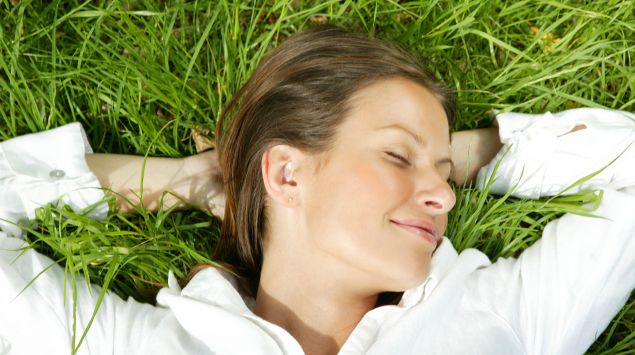 Das Bild zeigt eine Frau, die im Gras liegt.