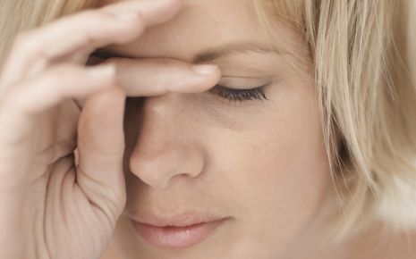 Man sieht eine müde, blonde Frau.
