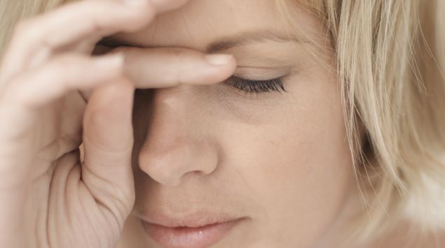 Man sieht eine müde, blonde Frau.