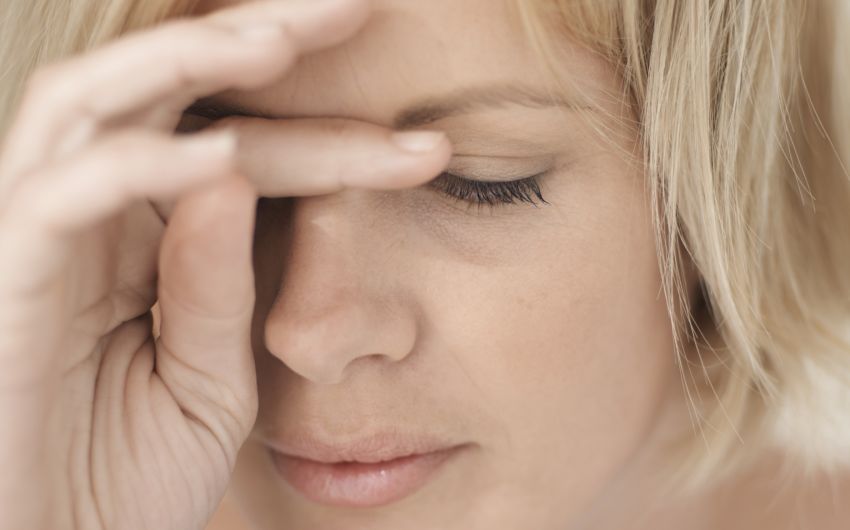 Man sieht eine müde, blonde Frau.