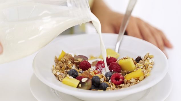 Das Bild zeigt einen Teller mit Müsli in den Milch gegossen wird.