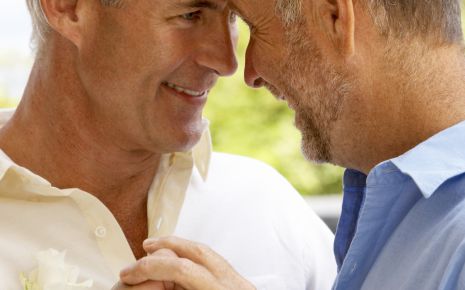 Ein homosexuelles, männliches Paar, an einer Hand ist ein Ehering zu sehen.