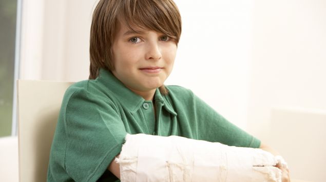 Das Bild zeigt einen Jungen mit Gipsarm.