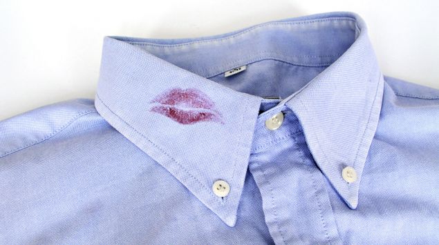 Man sieht einen Lippenstift-Kussmund auf einem Hemdkragen.