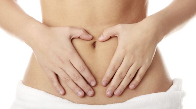Eine Frau hält sich den Bauch.