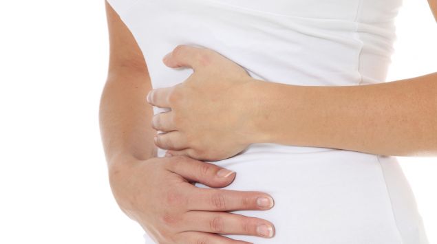 Eine Frau hält sich die Hände auf den Bauch.