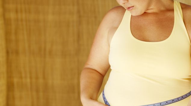 Das Bild zeigt eine übergewichtige Frau mit Maßband um die Taille.