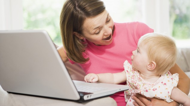 Das Bild zeigt eine Frau und ein Baby am Laptop.