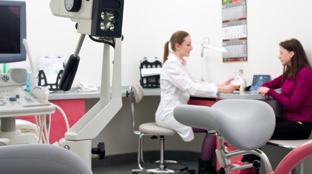 Eine Frauenärztin im Gespräch mit einer Patientin, im Vordergrund medizinische Geräte.