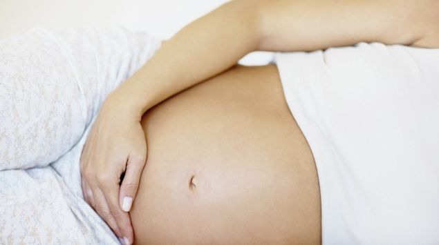 Das Bild zeigt den nackten Bauch einer liegenden Schwangeren.