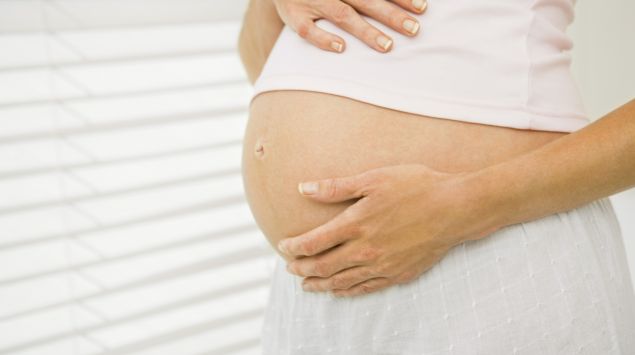 Eine schwangere Frau hält sich den Bauch. Fühlen, ob ihr Baby in Beckenendlage liegt, kann sie vermutlich nicht