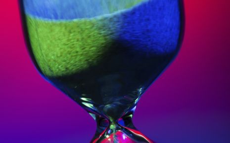 Man sieht eine Sanduhr in bunten Farben.