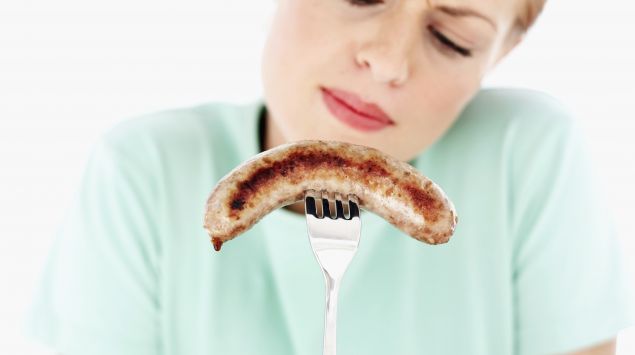Das Bild zeigt eine Frau mit einer Bratwurst.
