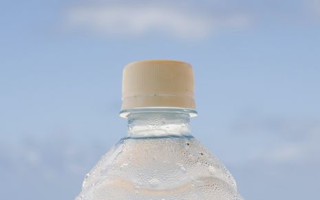 Eine Wasserflasche, im Hintergrund das Meer.