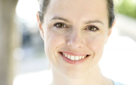 Man sieht eine lachende Frau, die Zuversicht ausstrahlt.