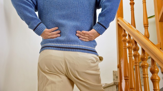 Spinalkanalstenose: Ein Mann hat Schmerzen beim Treppensteigen.