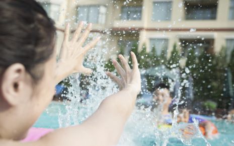 Kinder im Schwimmbad spritzen mit Wasser.