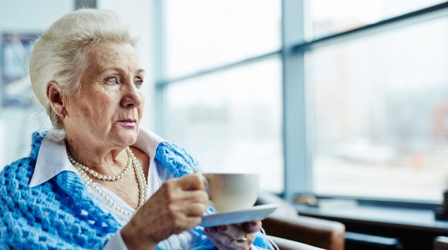 Weißhaarige ältere Frau mit Teetasse.