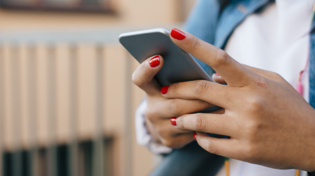 Phantom-Vibrationen: Eine Frau prüft ihr Smartphone auf neue Nachrichten.