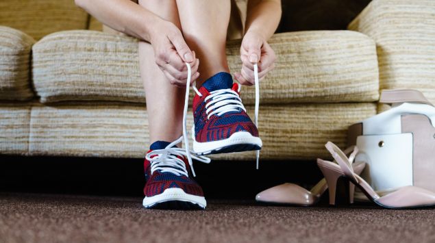 Eine Frau zieht sich Sportschuhe an.