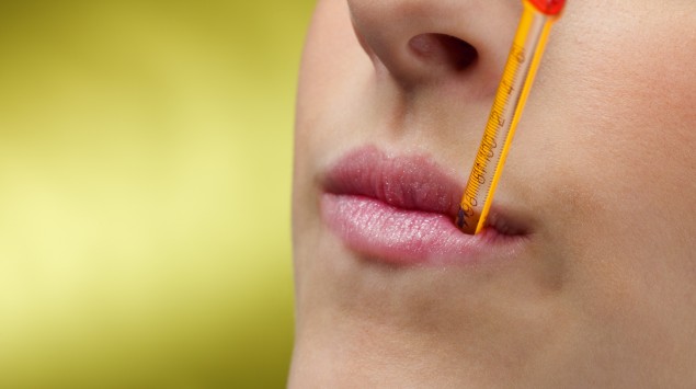 Frau mit Thermometer im Mund