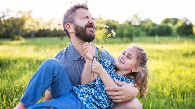 Vater und Tochter spielen mit Blumen