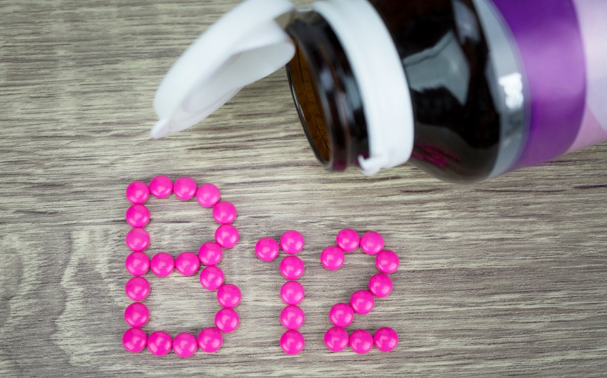 Vitamin B12: Man sieht den Schriftzug B12 aus pinken Tabletten gelegt.