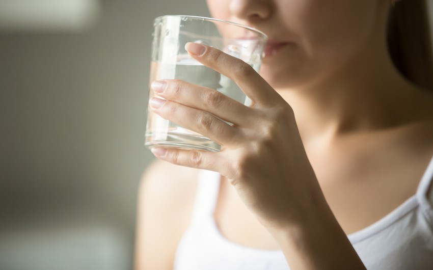 Durchfall: Eine Frau trinkt aus einem Glas Wasser.