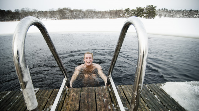 Ein Mann badet in einem eiskalten See.