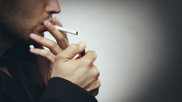 Ein Mann steckt sich eine Zigarette an.